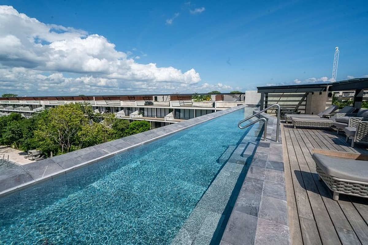 Golden-hour sunset at the adults-only rooftop infinity pool in the common area at AWA Playacar, creating a calm and refined Playa del Carmen experience.
