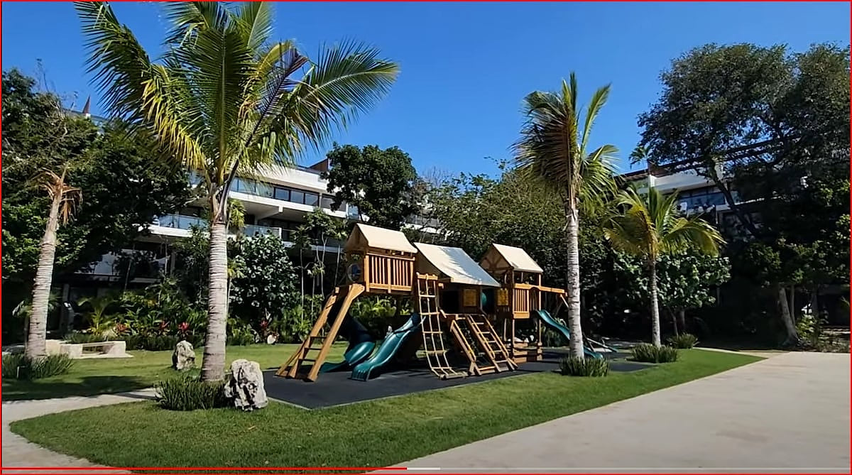 Family Friendly outdoor playground surrounded by lush gardens at Awa Playacar, ideal for guests traveling with children.