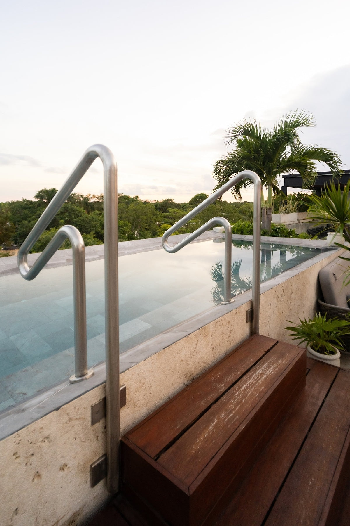 Golden-hour sunset at the adults-only rooftop infinity pool in the common area at AWA Playacar, creating a calm and refined Playa del Carmen experience.