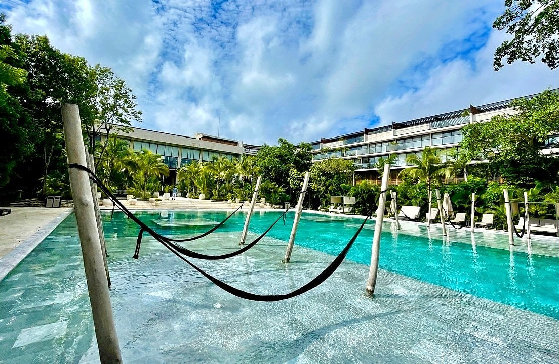 Relaxing in-pool hammocks at AWA Playacar’s resort-style pool, a unique luxury amenity in Playa del Carmen