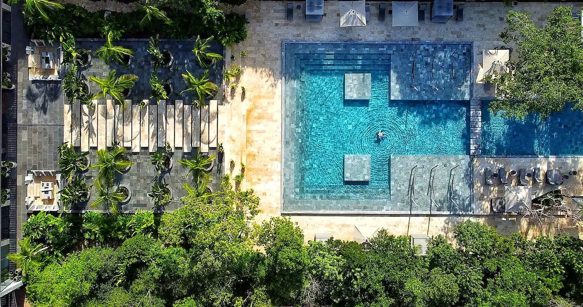Aerial view of the resort pool at AWA Playacar, showcasing modern design, crystal-clear water, and lush tropical surroundings