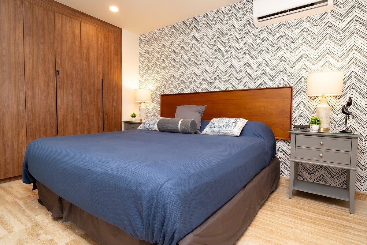 This serene bedroom retreat exudes tranquility, featuring a plush blue comforter and an array of pillows in complementary hues.   Custom Built in closet. 