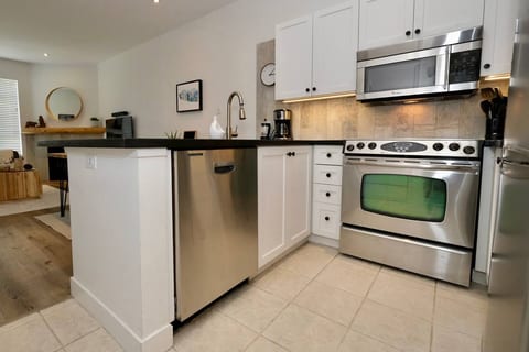 Kitchen - Fully equipped kitchen includes new cookware, plates, glasses for your stay. The kitchen also features a black granite countertop, under counter lighting, coffee station, fridge, stove, toaster, dishwasher, and microwave.
