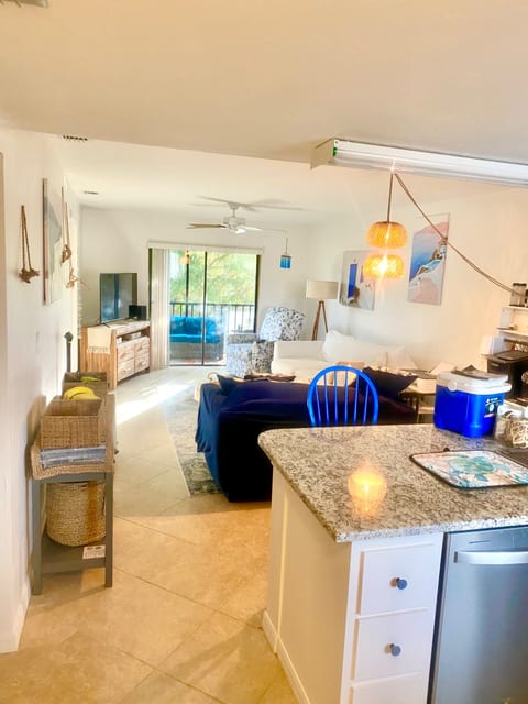 Main through way from front door, kitchen, living room, and patio, with both bedrooms to the left of living room wall, and laundry center next to 2nd bedroom and bathroom
