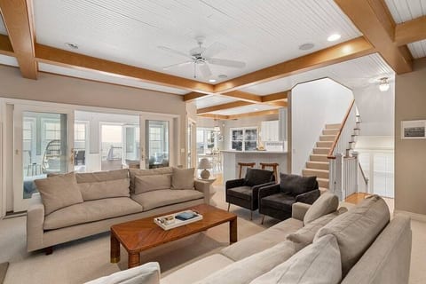 Main level living room is open to the kitchen, dining room, and sunroom for easy entertaining and gathering.