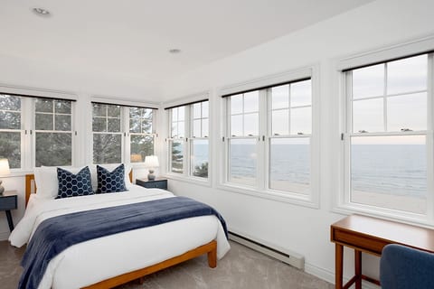 Third level queen bed room has access to the primary bath. Amazing views and remote control shades make this space a home favorite. Remote work is also available in this room with a desk facing Lake Michigan and sliding doors for privacy.