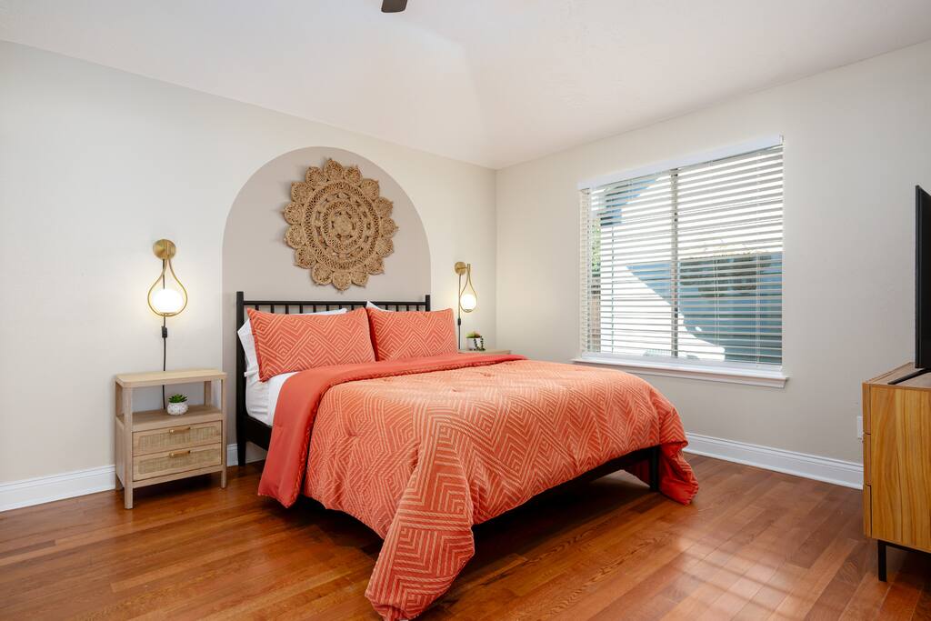 A serene retreat with a queen-size bed, plush bedding, and gentle light from side lamps and window