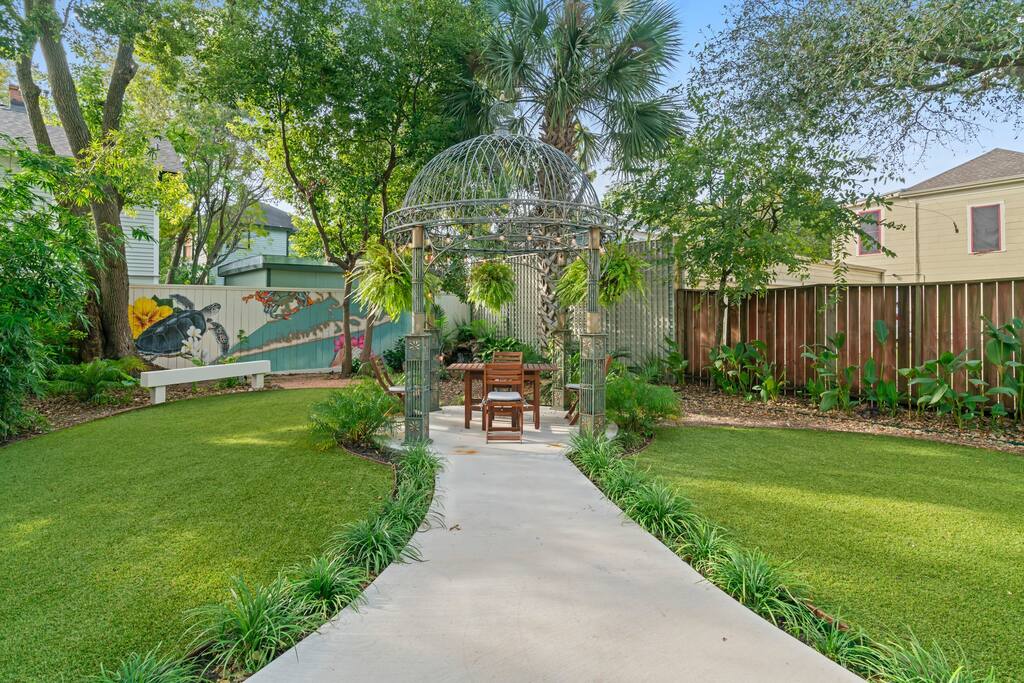 The backyard is large with lush grass and plants! Seating area to enjoy the wonderful Galveston weather and drink in the sunlight! 