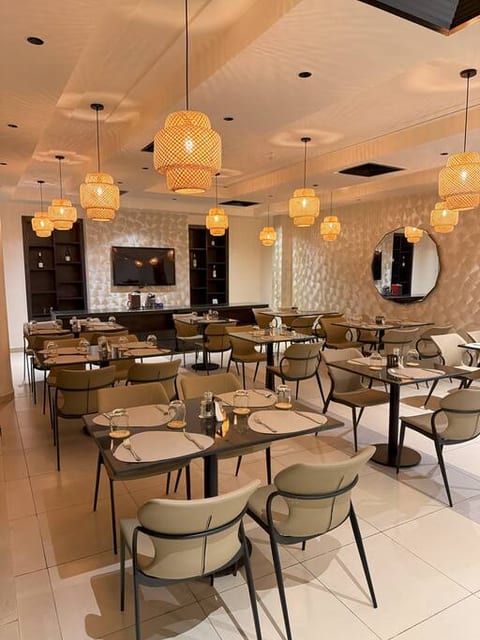 This elegant restaurant features modern décor with warm lighting and stylish chandeliers. The spacious seating layout creates a welcoming and comfortable dining atmosphere.