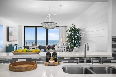Kitchen open to counter seating, dining and living room, all with ocean views