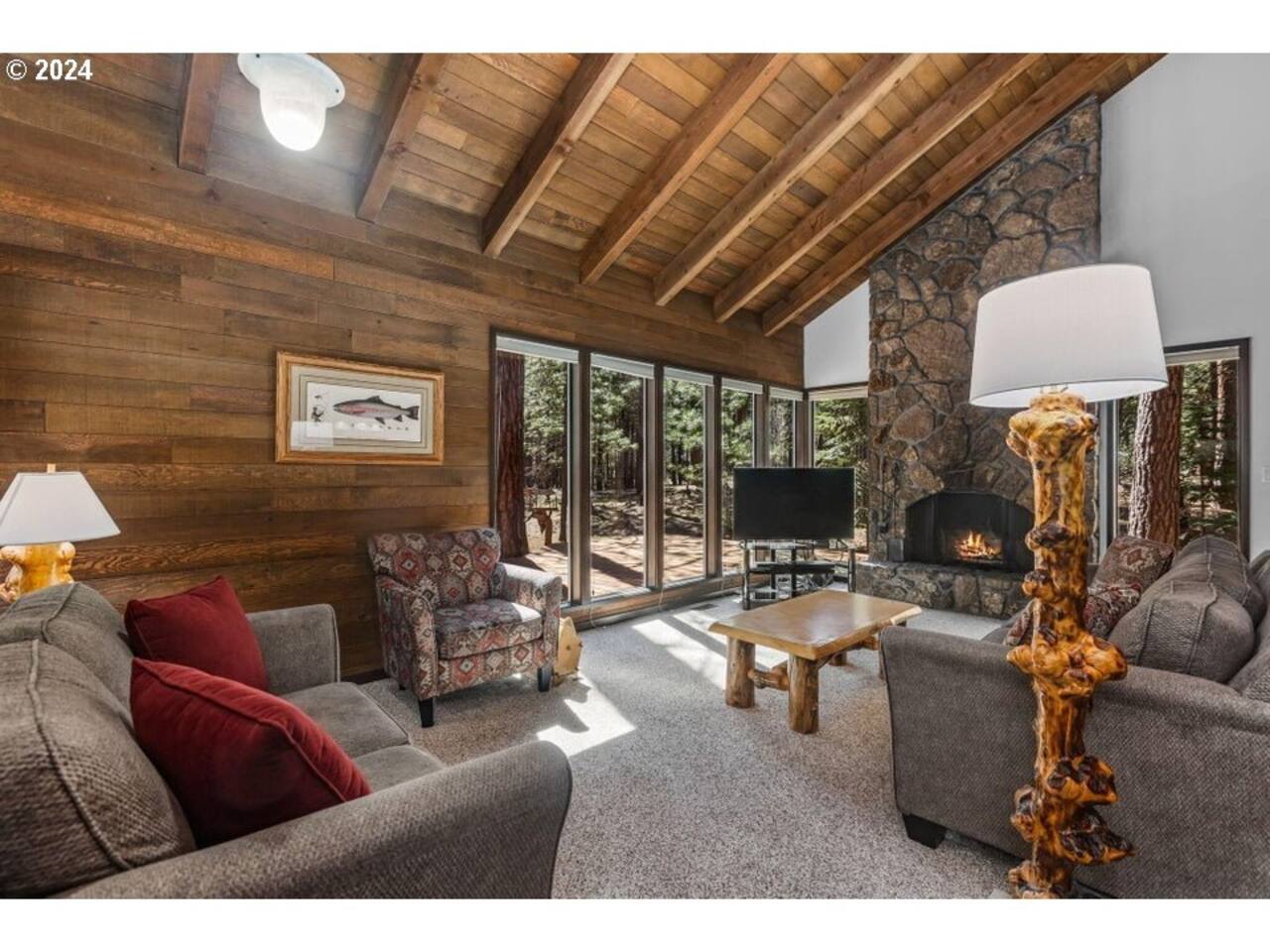 Living room includes couches, chairs, and a fireplace overlooking the deck, hot tub, and forested greenspace.  The TV is equipped with Roku for all your streaming services. 