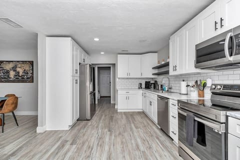 Upgraded kitchen with plenty of cabinets, wine/coffee nook, recessed lights, newer fridge/freezer and dishwasher and over/stove and microwave, with plenty of pots to cook with. Right off dining room, laundry room, and family room, leads to garage.