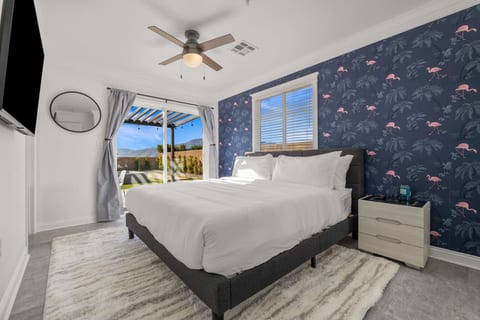 Cozy bedroom w/ bold accent wall, soft bedding & a calm setup for restful nights.
