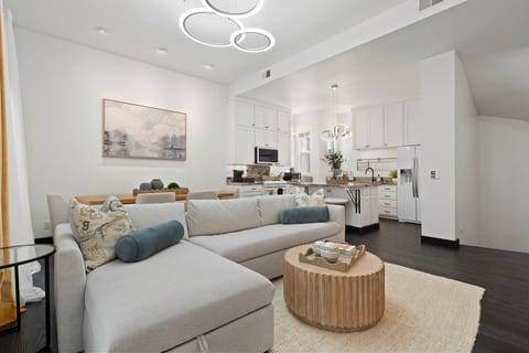 Open living area w/ comfy seating, soft tones & natural light flowing through the space.