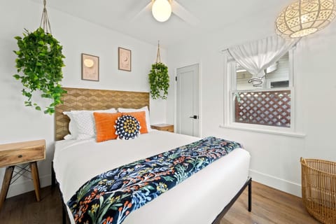 Inviting bedroom w/ crisp linens, colorful pillows & a calm setup for a great night’s sleep.