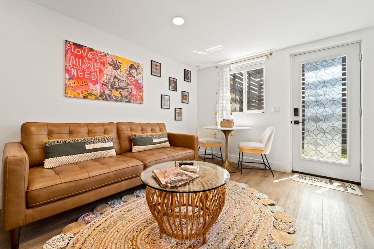 Bright living area w/ cozy sofa, round coffee table & pops of art, perfect for relaxing after a day out.