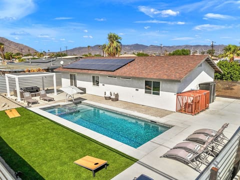Bird’s-eye view of the desert retreat w/ private pool, sun loungers, and relaxed outdoor spaces framed by mountain skies.