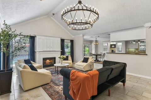 Living area with high ceilings, sleeper sofa, tile floors and gorgeous chandelier
