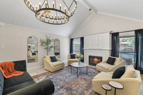 Living area with high ceilings, fireplace, and Tv behind the closed cabinetry