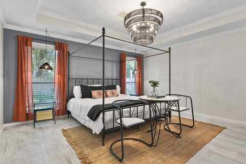 Master bedroom with four poster canopy bed, table and 2 chairs for a private sitting area.