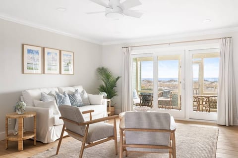 Spacious living room with plush seating, elegant decor, and large windows that frame the ocean views
