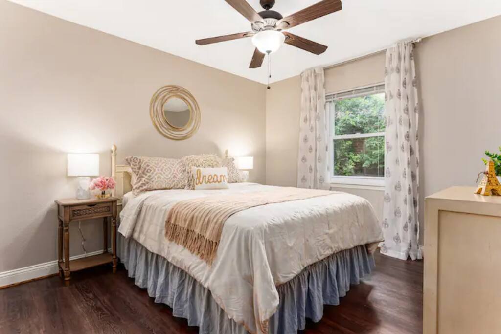 Relax in a serene bedroom featuring a ceiling fan, queen bed with bedside lamps, and luxurious bedding for restful nights