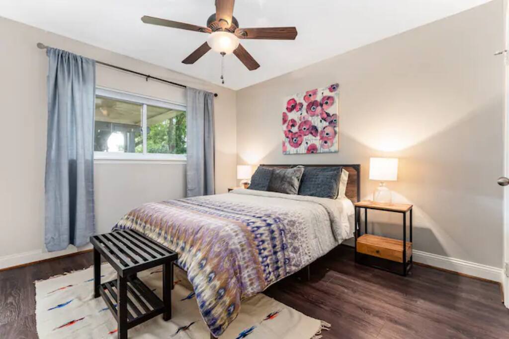 Unwind in this elegant bedroom with natural light, a ceiling fan, and premium bedding for your perfect stay