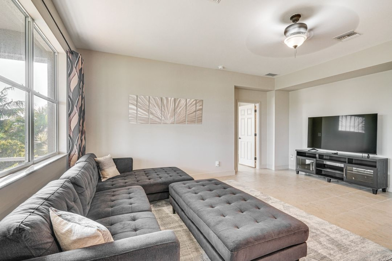 Unwind in this sunlit living room, where cozy seating and a relaxing atmosphere make it the perfect spot to recharge.