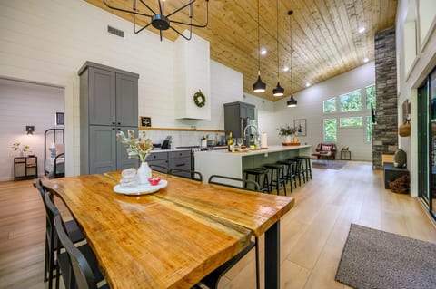 Embrace the natural beauty of wood with this kitchen's charming wood ceiling, creating a warm and inviting space to gather around the chic bar stools.
