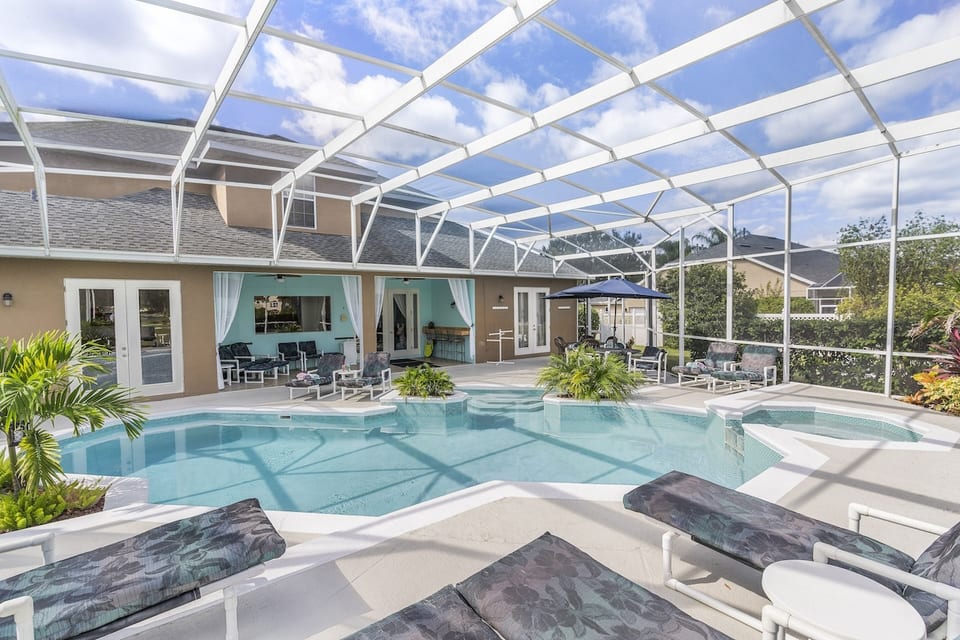Mickey's Oyster 9 Bedroom 8 Bathroom Sleeps 18 People 2 Miles to Disney Gorgeous large tropical pool area with spa, surrounded by palm trees and shrubs.