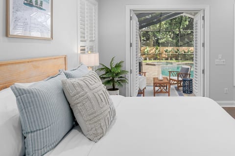 Wake up to natural light and peaceful pool views from this bright, inviting bedroom