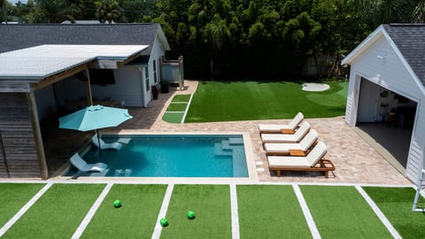 Aerial view of your private retreat featuring heated pool, turf sports court, putting green, and resort style outdoor living.