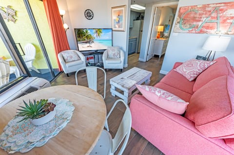- Warm and inviting living space with cozy seating and a stylish setup, perfect for unwinding - Open layout blends comfort and charm, making it ideal for relaxing or dining - Step onto the balcony for fresh air and enjoy the coastal breeze