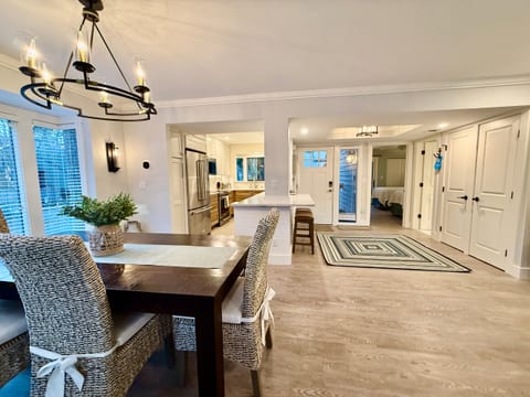 View from the bottom of the stairs to the dining, kitchen, front door and 1st floor bedroom.