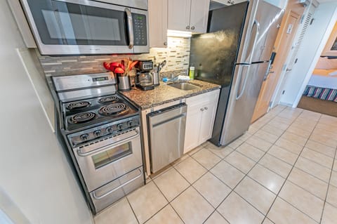 - Fully equipped kitchen featuring stainless steel appliances and granite countertops - Compact yet functional space with everything needed for home cooked meals - Stylish backsplash and modern touches make cooking a delight