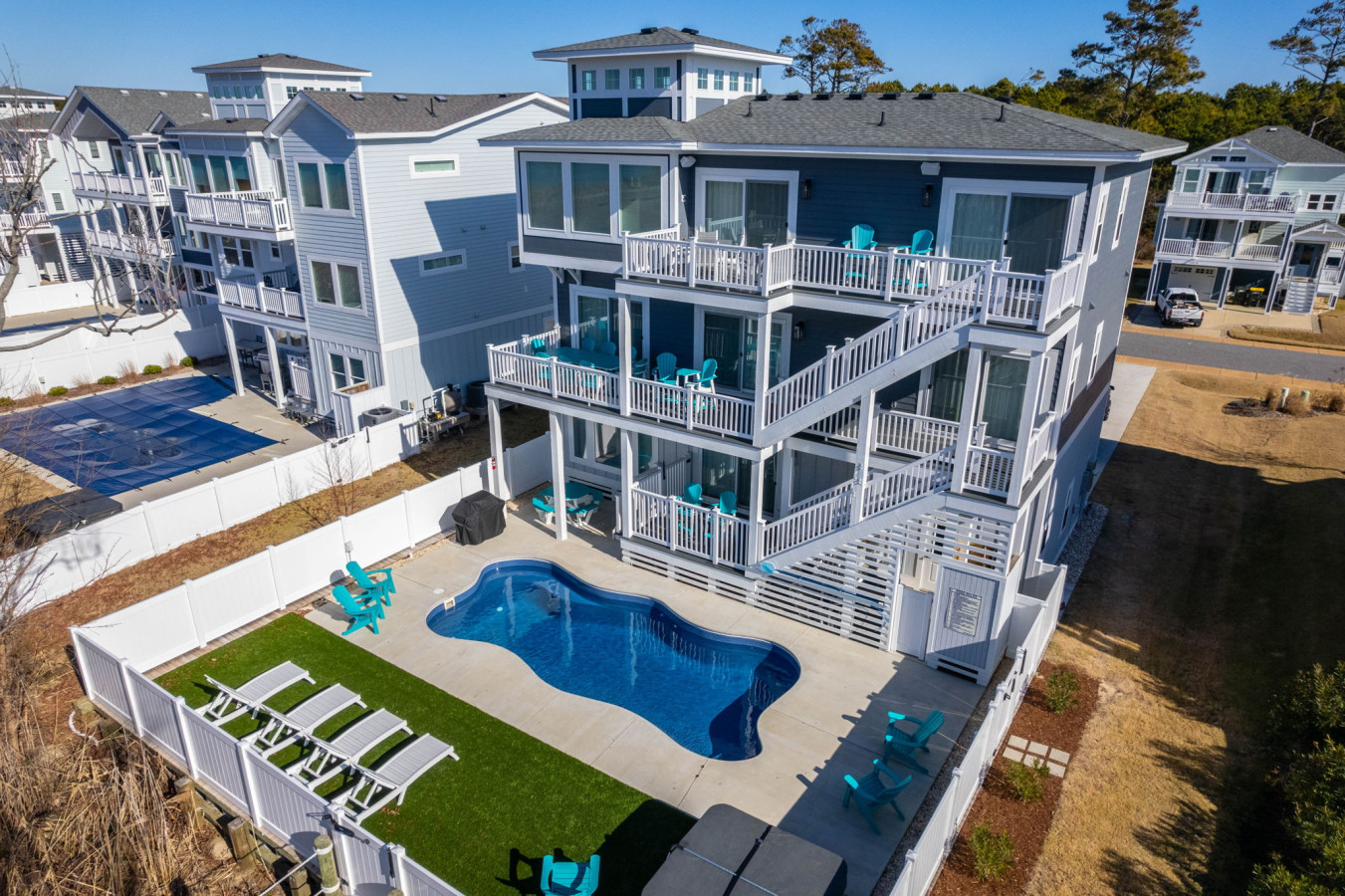 Striking aerial view of the home showcasing its pool, decks, & coastal setting