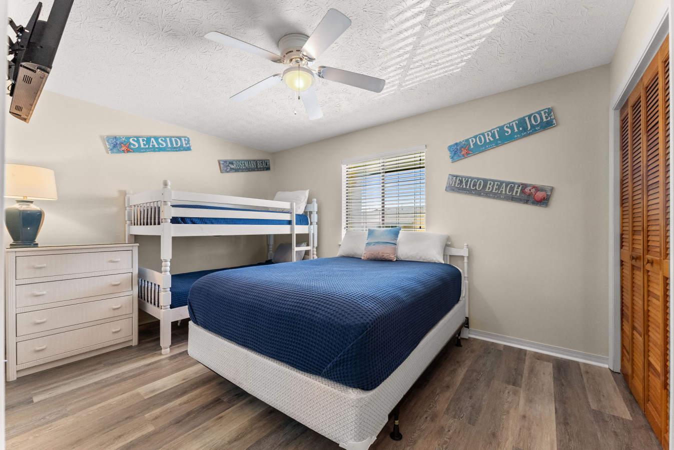 Spacious guest room with a comfortable queen bed and twin bunk beds, offering plenty of sleeping space for family and friends.