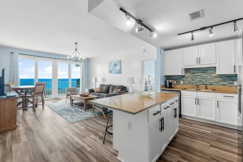 open-concept living with a fully equipped kitchen, granite countertops, and stunning ocean views from the spacious living and dining area