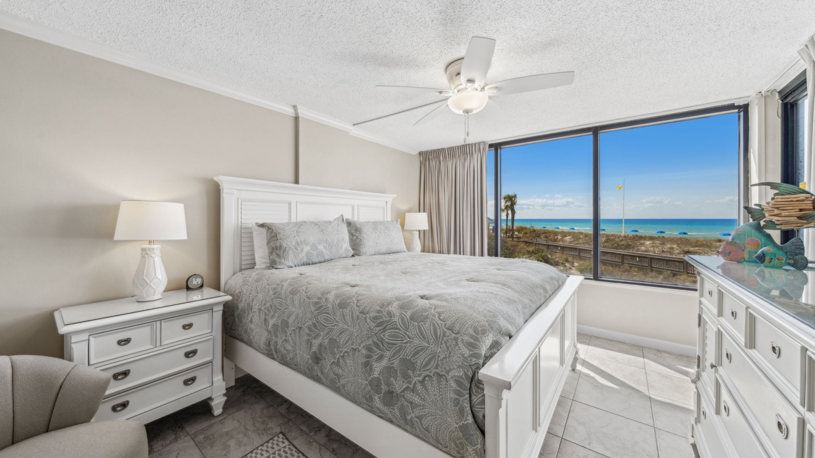 Wake up to breathtaking Gulf views in this serene beachfront bedroom with a plush king bed and coastal decor.
