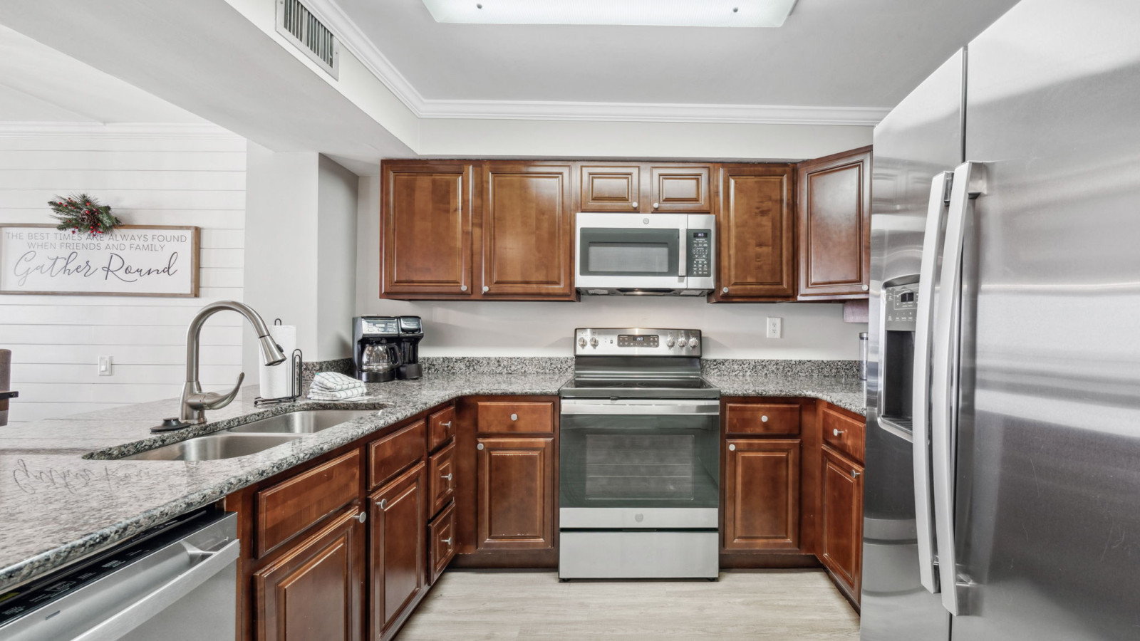 This fully equipped kitchen includes stainless steel appliances, granite countertops, and rich wood cabinetry, ideal for easy meal preparation during your beachfront stay.