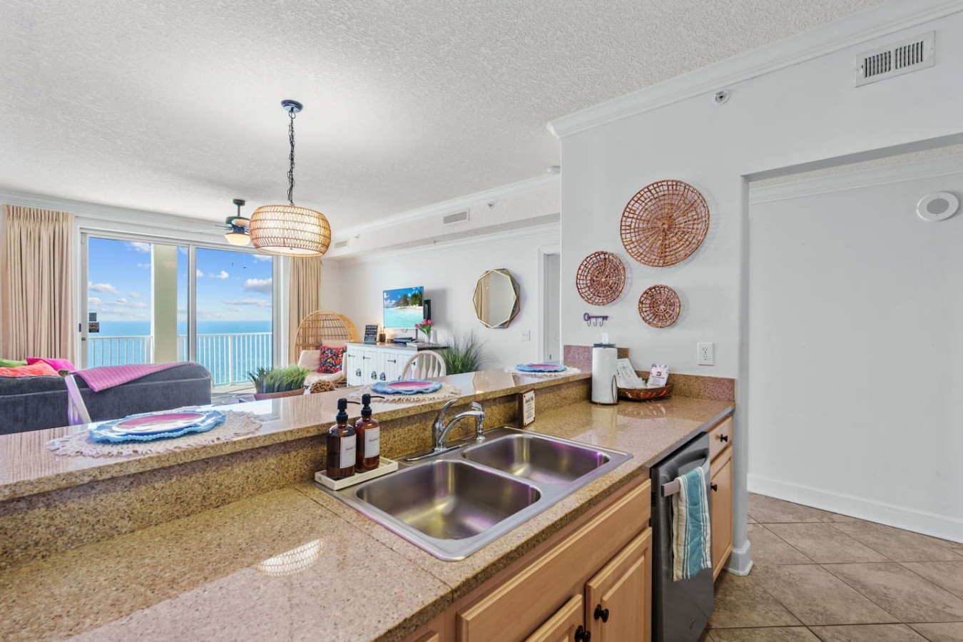 Prepare meals while enjoying the beautiful ocean views in this open-concept kitchen with a spacious bar top and inviting coastal decor.