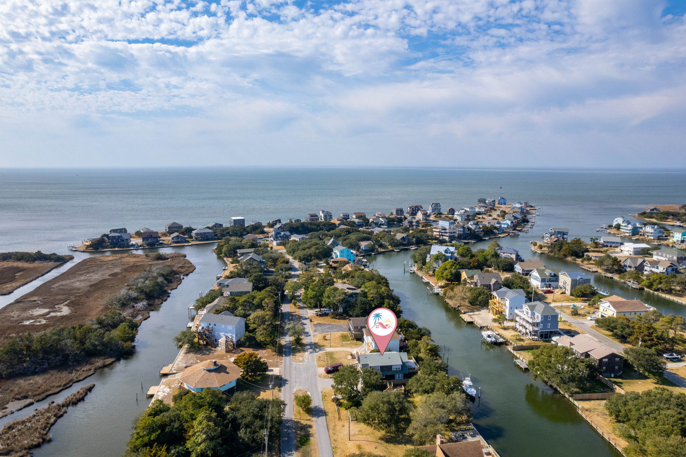 Aerial view of the waterfront neighborhood w/ winding canals and homes nestled along the water.