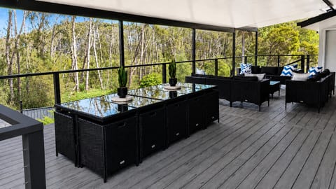 Upstairs Back Balcony Actions : A view across the upper back deck at Skye’s Beach House Malua Bay, looking out to the natural backdrop behind the property.