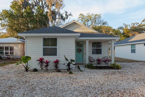 Charming Cottage: Bright exterior with vibrant plants and a welcoming turquoise door awaits you!