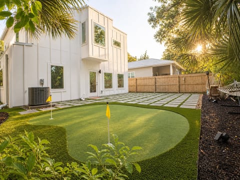 Modern backyard oasis with putting green, hammock & fenced patio