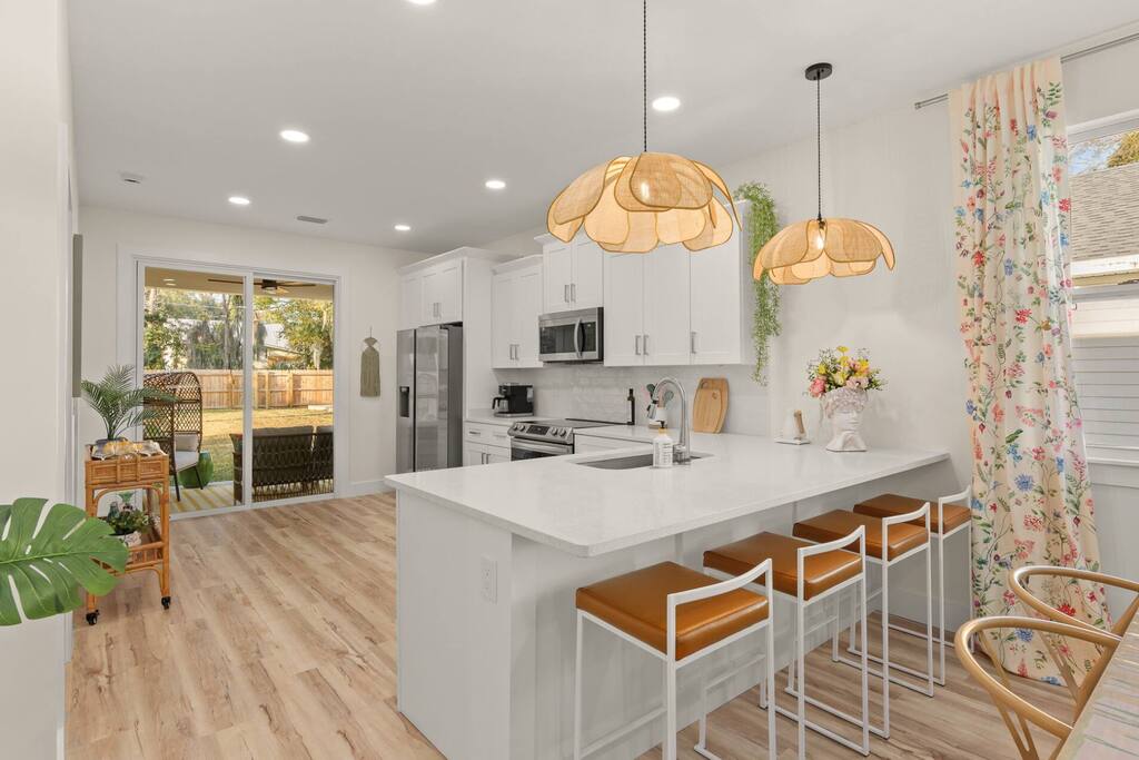 Kitchen: Bright and airy space with stylish seating and views of the lush backyard oasis!