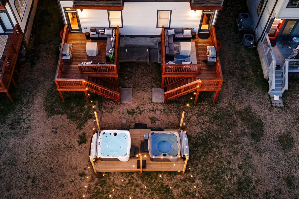 Private Backyard | 2 Hot Tubs | 2 Outdoor Decks | 2 Fire Pits | Charcoal BBQs
Unwind in twin private hot tubs under glowing string lights, just steps from two bistro-lit back decks with cozy lounge seating— plus 4 swinging hammock chairs just added!