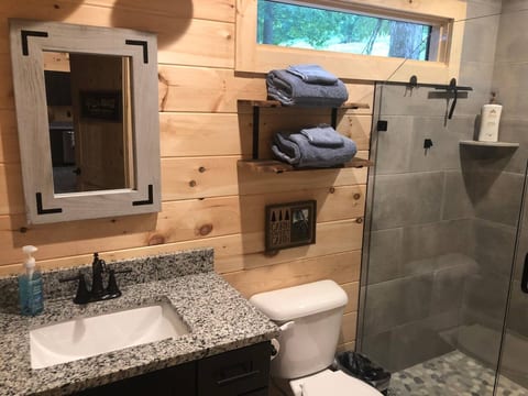 Luxury bathroom with granite counters and tile floor and shower.