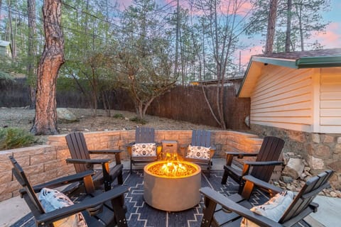 Relax with your guests in the backyard. Six adirondack chairs surround a propane firepit. Pine trees tower above making this the perfect ambiance.