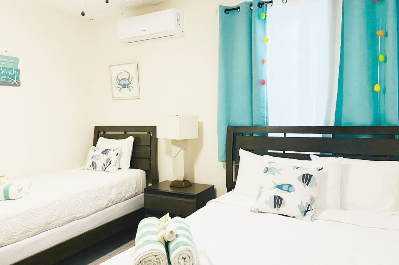 First Floor Bedroom 2: Bright space with playful decor, two comfy beds, and a beachy vibe!